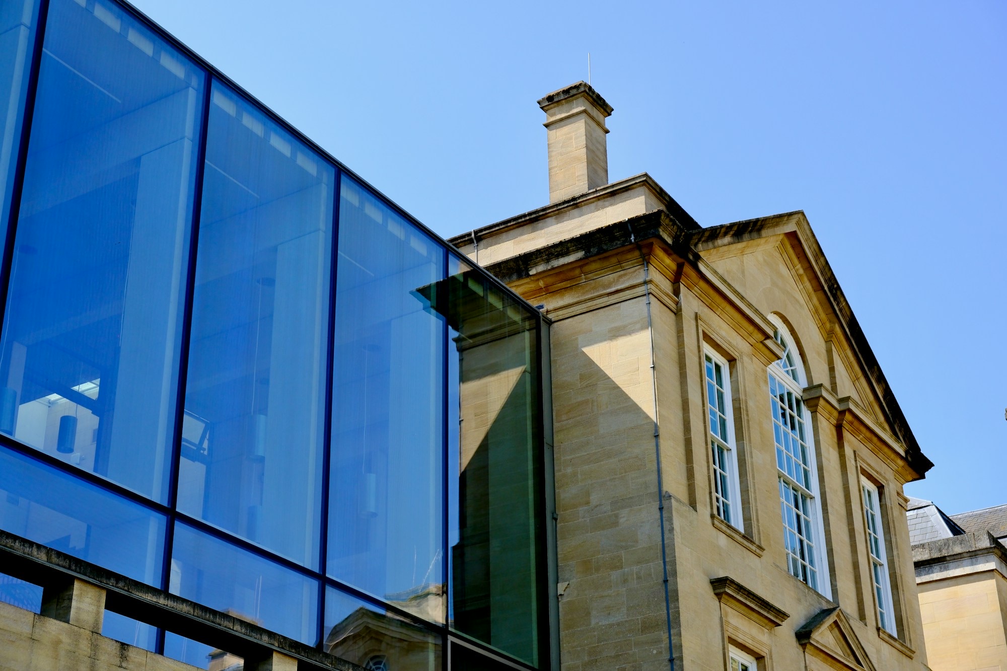 Modern glazed extension against a classical stone house